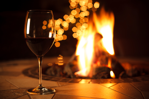 Glass of red wine by firepit