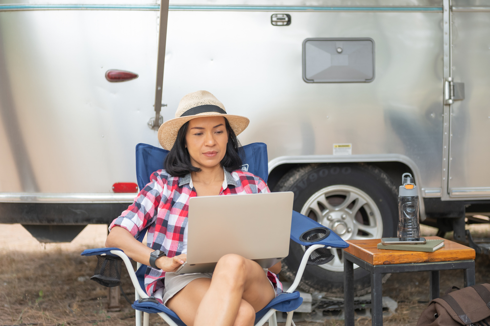 Woman on laptop outside RV