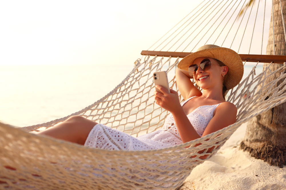 woman in hammock looking at phone