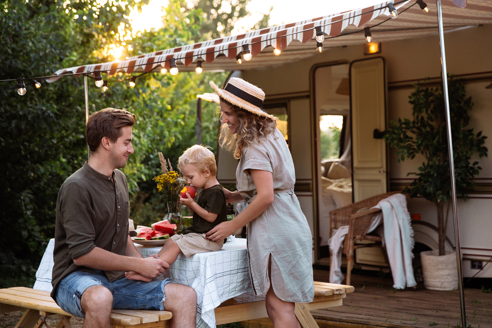 Family having snack at table outside RV