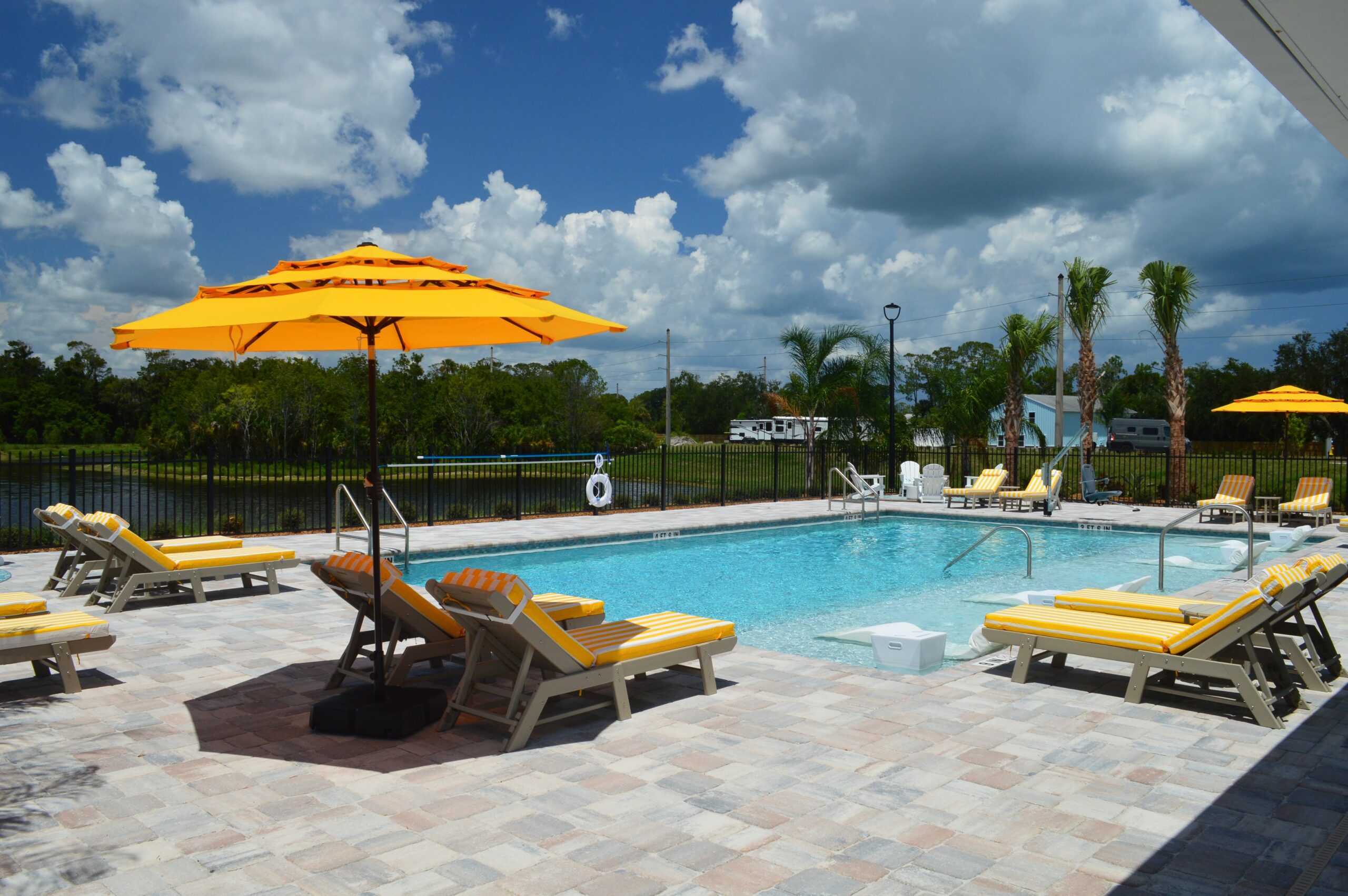 Pool that has sun shelf with chairs